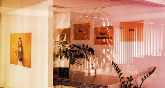 Photographs were taken through a window onto a wall on which the individual values of JobRouter AG are printed on panels. 